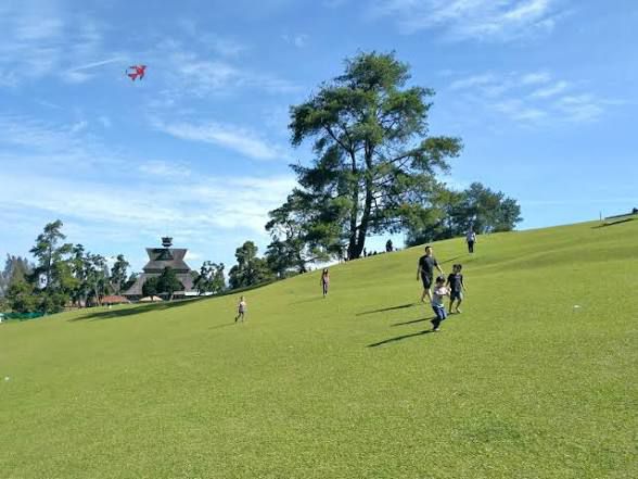 Aktivitas piknik santai di lapangan hijau luas Bukit Kubu Berastagi